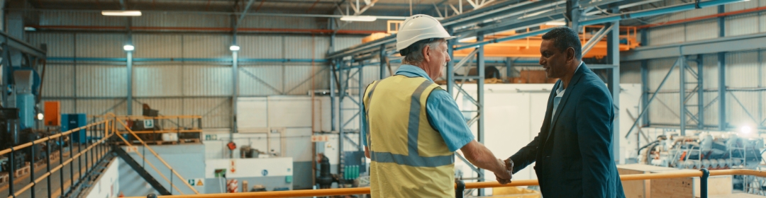 Image of two people shaking hands in a warehouse
