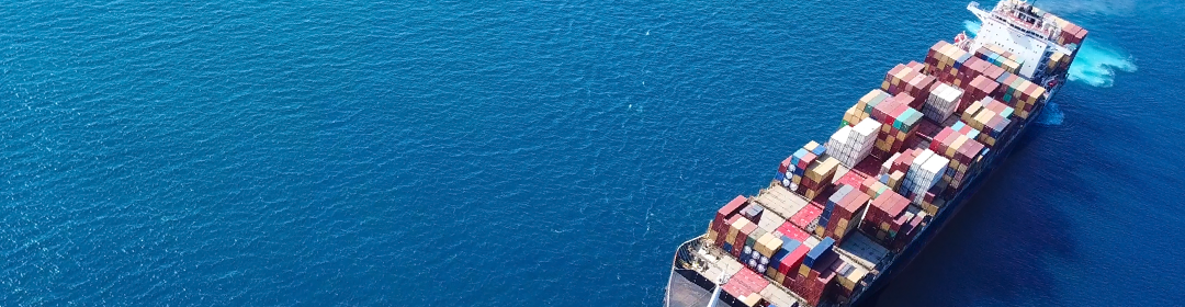 Aerial view of cargo ship travelling across ocean